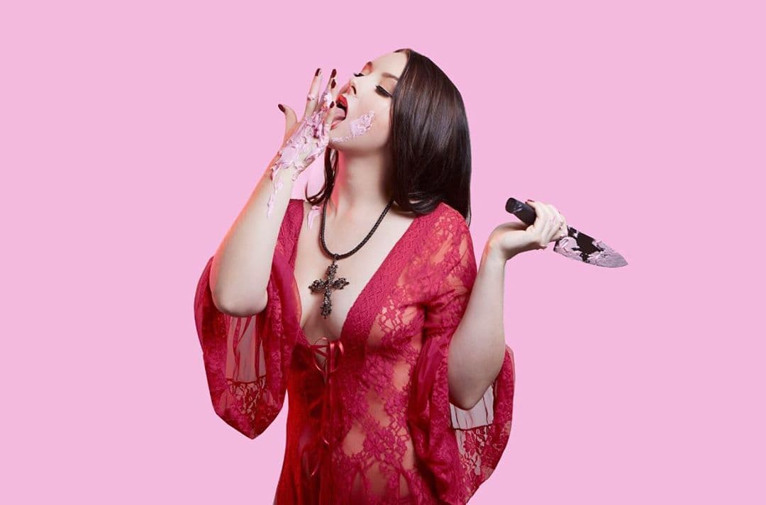 Mae Deline doesn’t hold back, her new song “Wedding Cake” is deeply personal yet she makes it tongue-in-cheek and playful. That’s exactly what we expect from her, A glittery shell hiding a darker subject. We talked to the up-and-coming artist about the story behind the song and the double standard