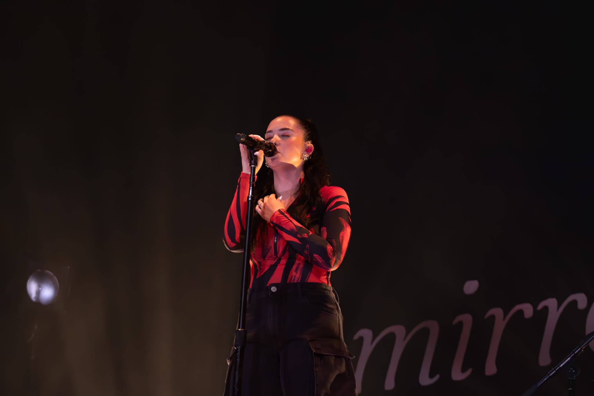 Lauren enters the stage in her fiery red outfit, wearing all black with a black and red shirt. She kicks off the show by singing her song, “Never Been in Love,” while standing on the steps in the middle of the stage. A fan throws a Canadian flag on stage, and she wraps it around her. When the song